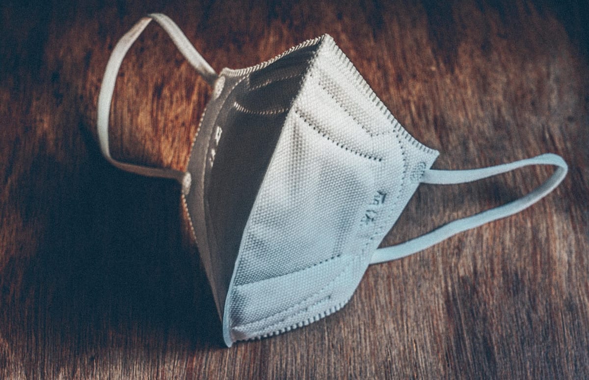 A white ffp2 mask sat on a wooden table